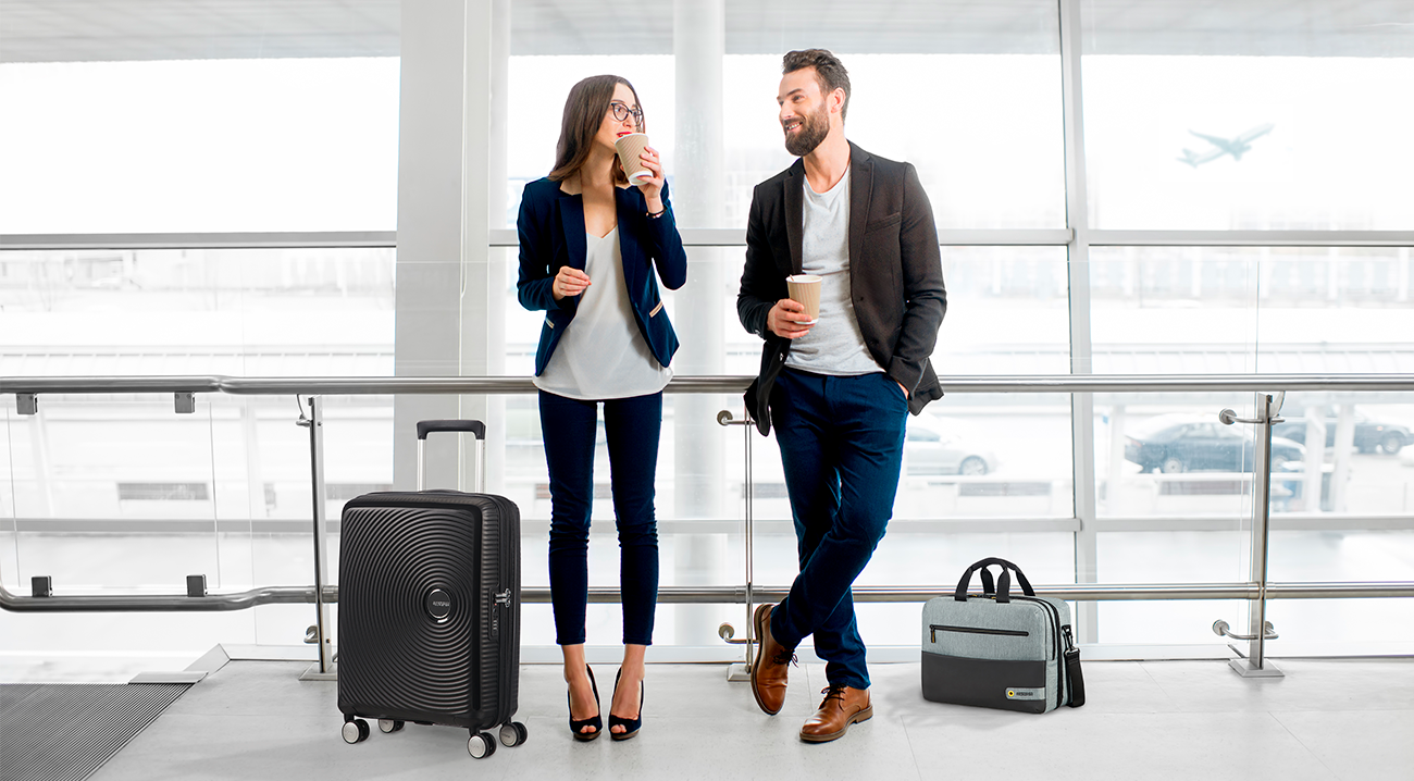 Счастливая командировка. Мужчина и женщина в аэропорту. Мужчина с чемоданом в аэропорту. Мужчина и женщина с чемоданами. Пара в аэропорту с чемоданами.